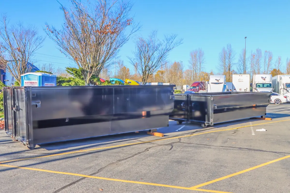 Professional dumpster rental service with roll-off container on residential driveway in West Donegal